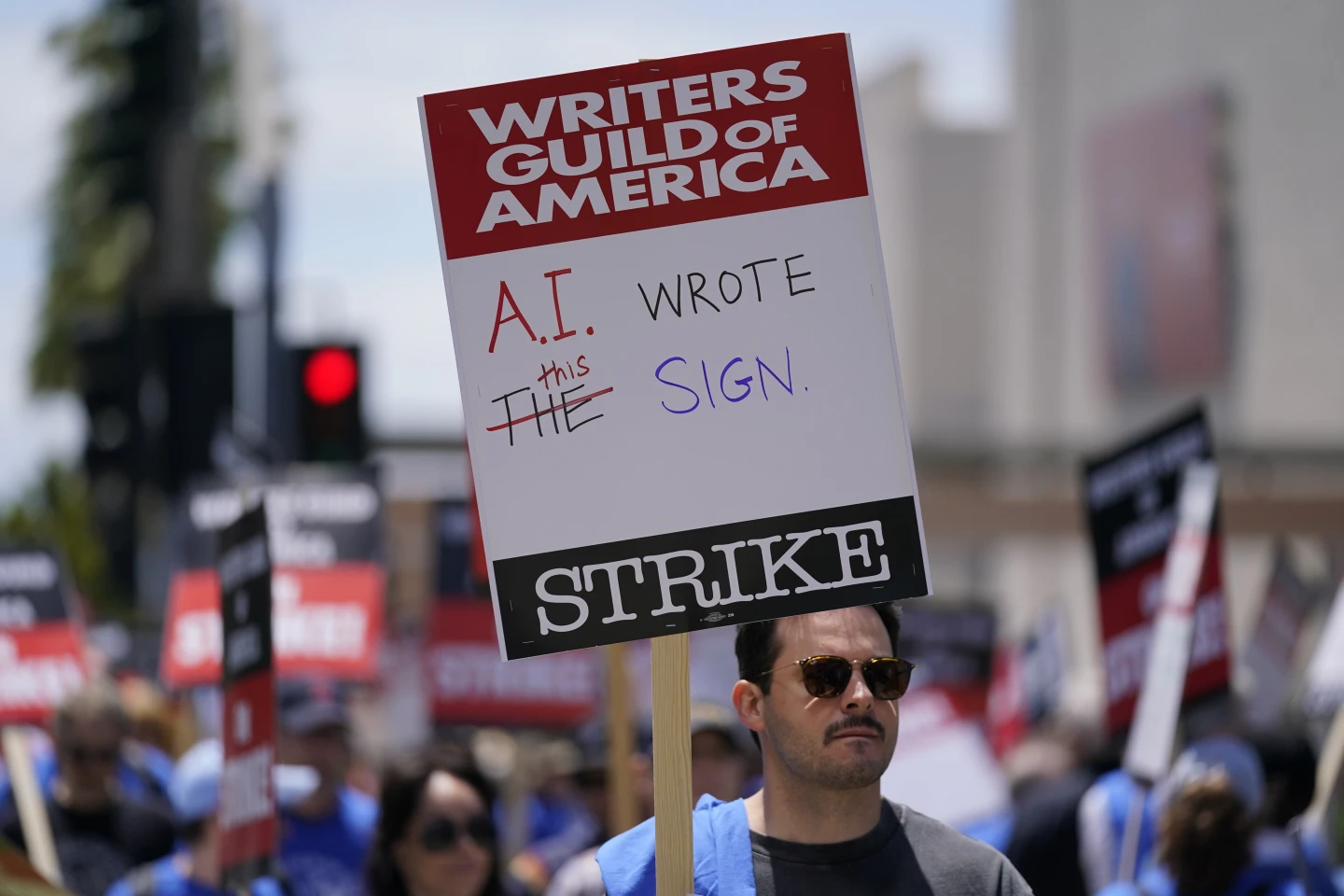 A WGA picketer demonstrates the fallibilities of the use of AI in scriptwriting. (Ashley Landis)